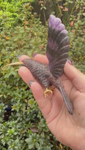 Load and play video in Gallery viewer, Handcarved Sugilite Humming Bird on a Quartz and Pyrite Base with a Mangano Calcite Flower and Serpentine Petals
